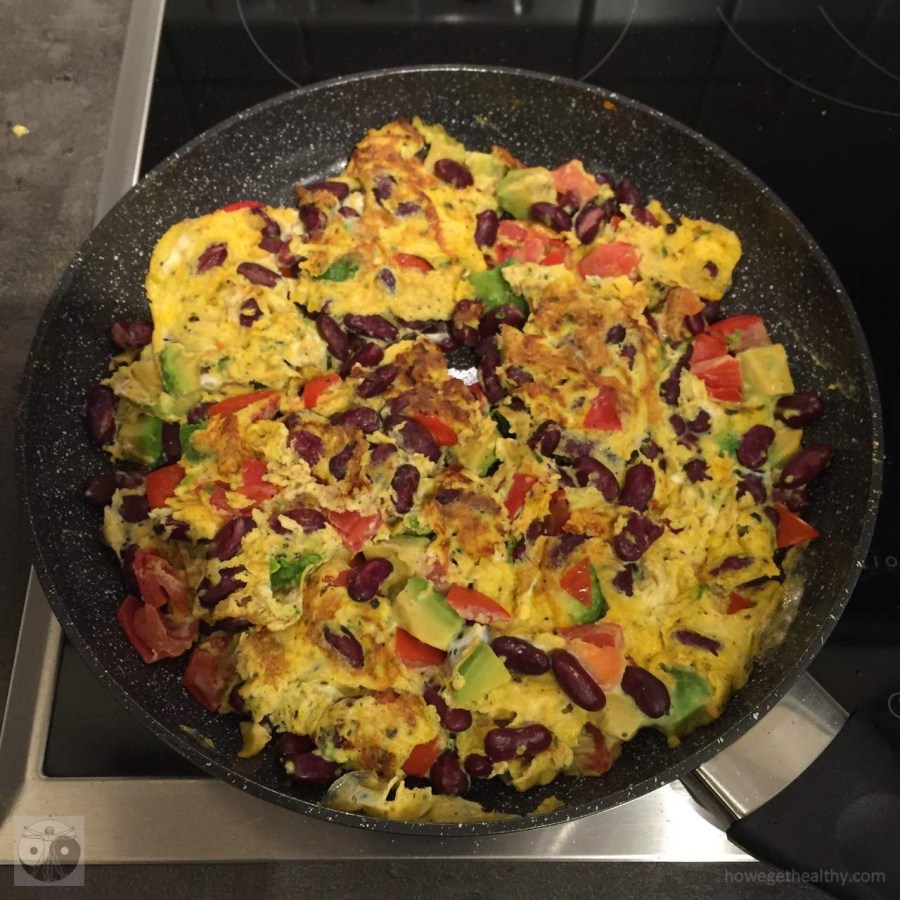 Rührei mit Bohnen und Avocado in der Pfanne