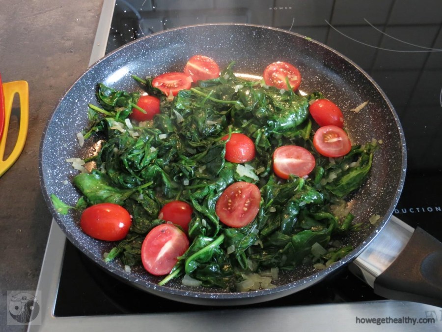 Rührei mit Spinat und Tomaten in der Pfanne