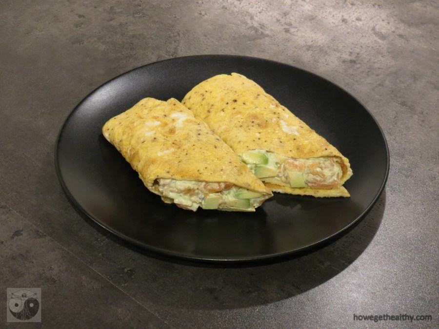 Frühstücksrolle mit Lachs-Avocado-Mayonnaise auf dem Teller