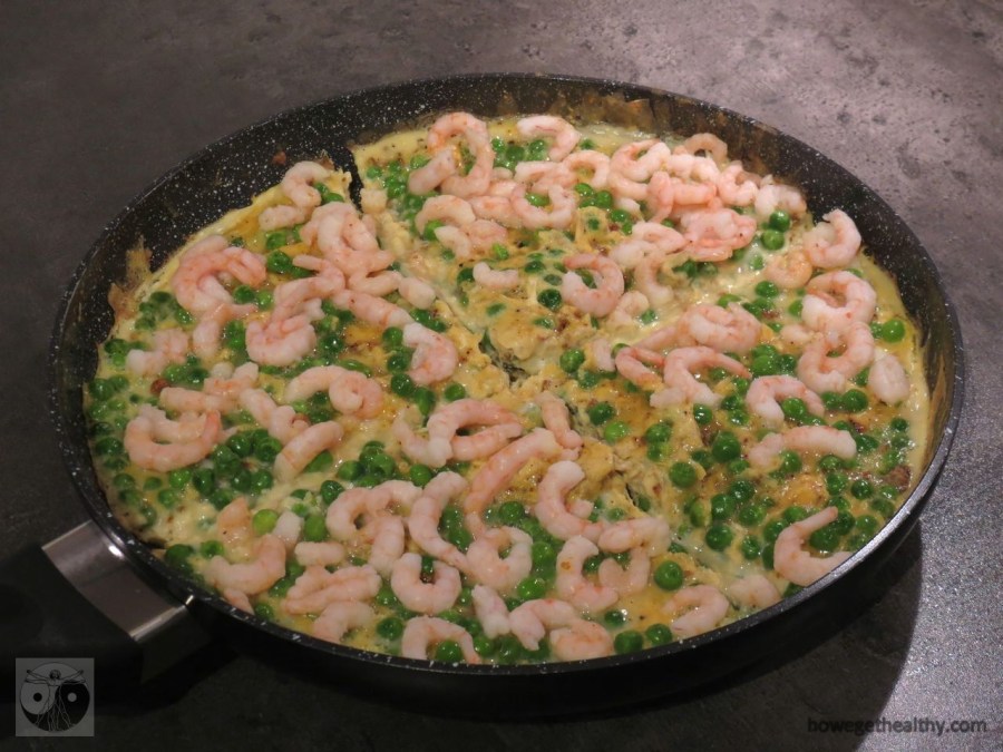 Rührei mit Krabben und Ebsen in der Pfanne